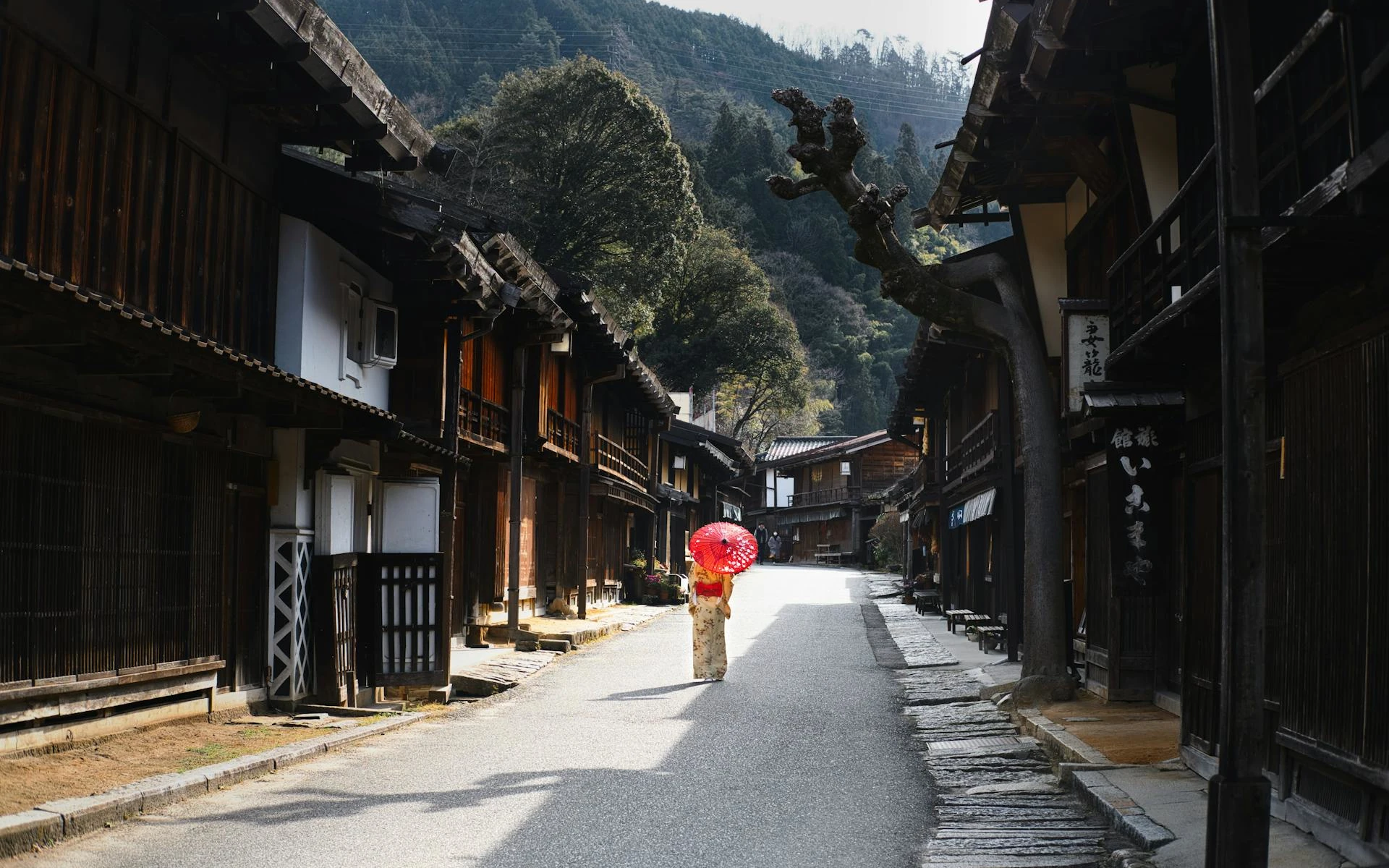 Woman in traditional Japanese kimono walking through a historic street in Kyoto, Japan.