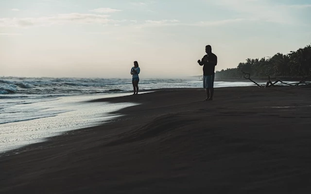 Dos personas en la playa del Parque Nacional Tortuguero Dos personas en la playa del Parque Nacional Tortuguero