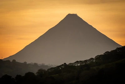 La silueta del volcán Arenal con un cielo naranja La silueta del volcán Arenal con un cielo naranja
