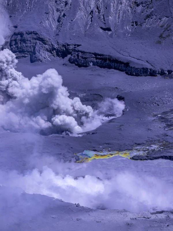 A large plume of smoke coming out from a volcanic crater A large plume of smoke coming out from a volcanic crater