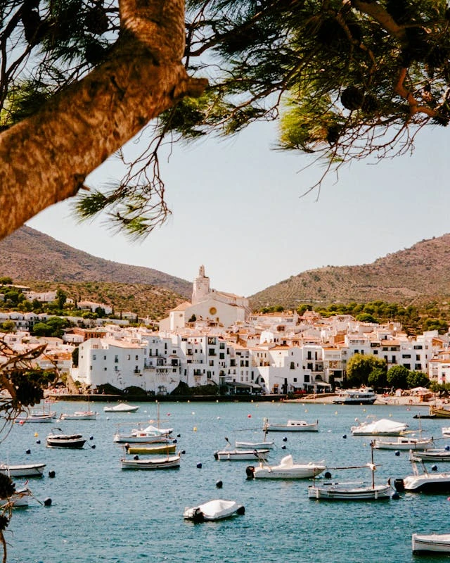 The white village of Cadaqués with its church on the hill overlooking the bay full of boats