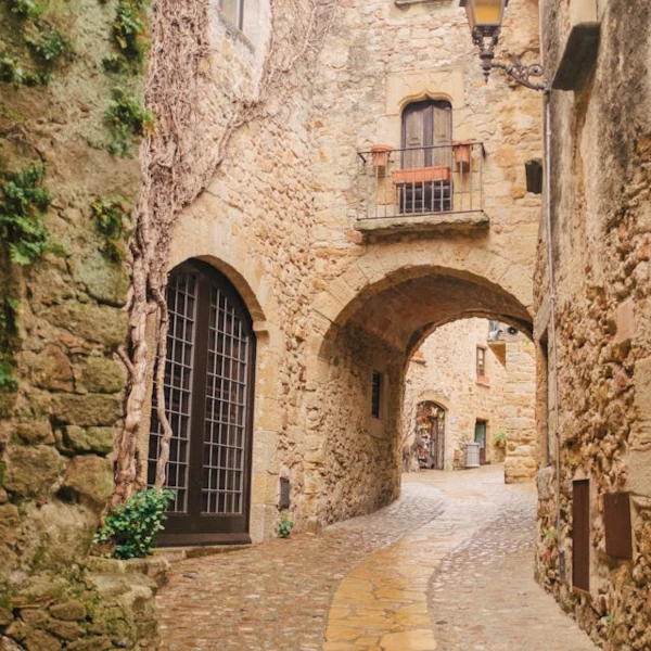 Medieval cobbled street passing under an arch