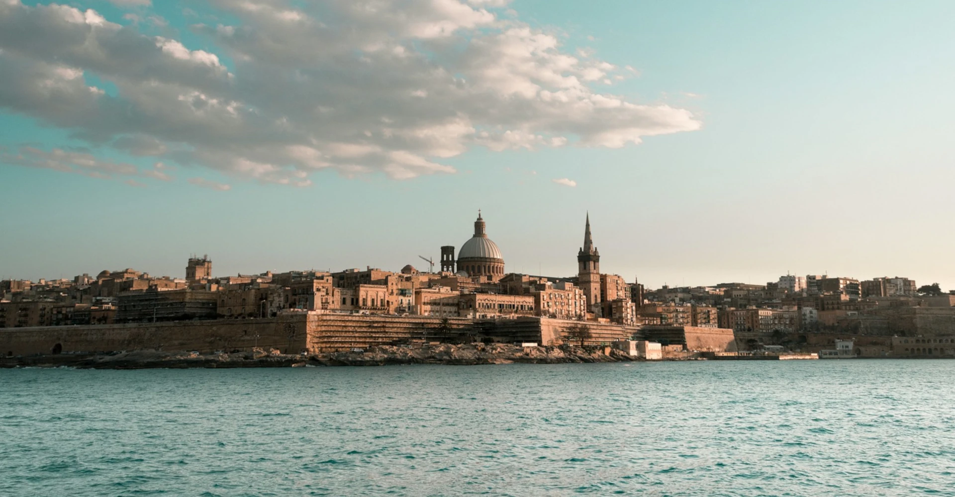 Panoramic view of Valletta’s skyline from Sliema, highlighting domes and church towers rising above the historic cityscape