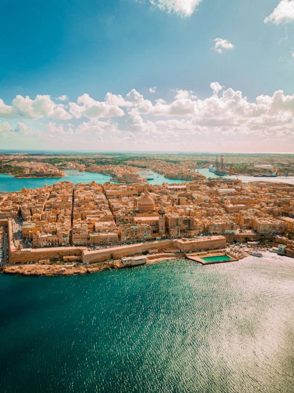 Aerial view of Valletta, Malta’s historic capital, on a sunny day with blue skies and harbors.