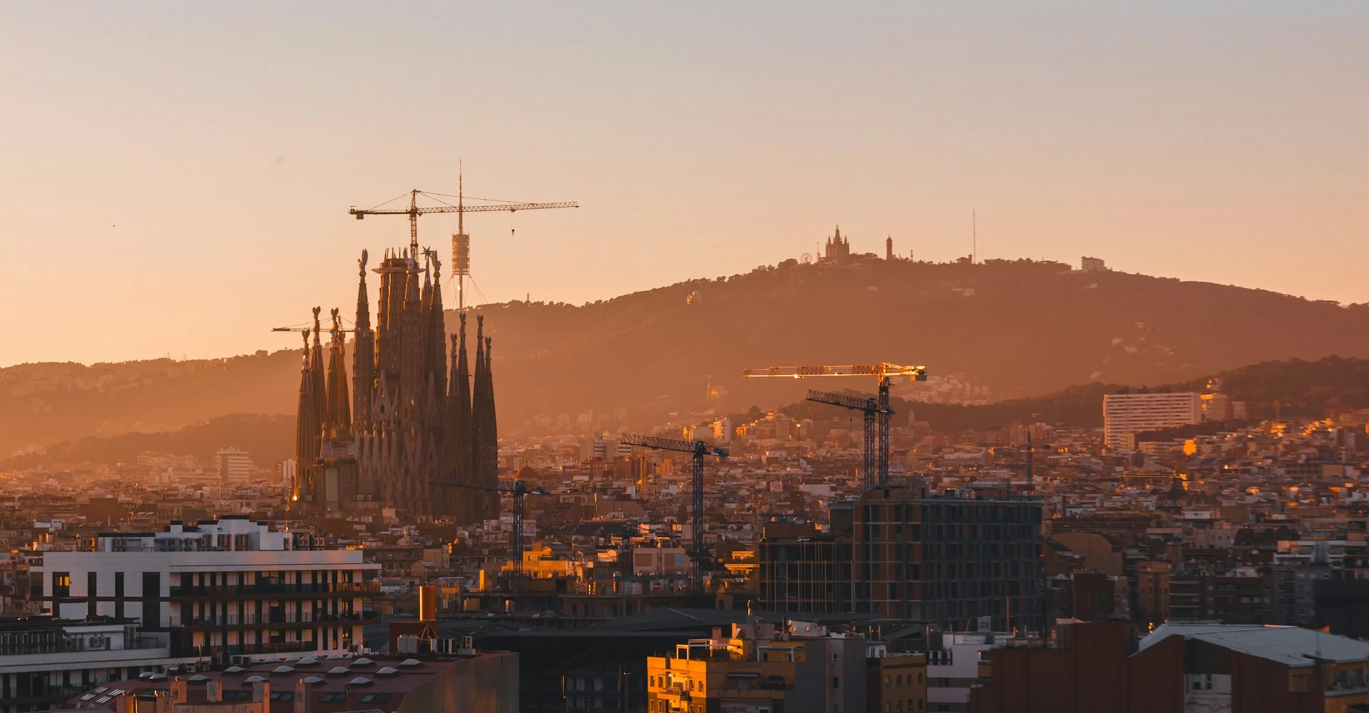A view of the skyline of Barcelona with the Sagrada Família being much more higher than the rest of the buildings during sunset
