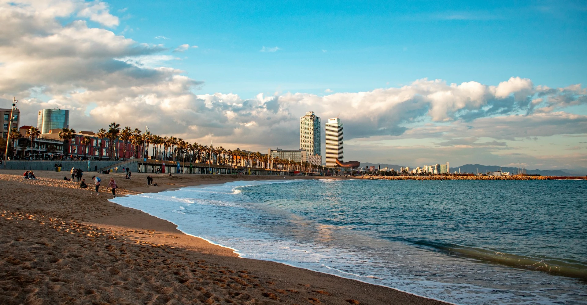 The seafront promenade and buildings of Barcelona, and the calm and golden beach in front