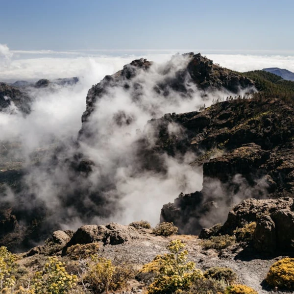 The mountains of Gran Canaria covered in clouds, with a blue sky above them
