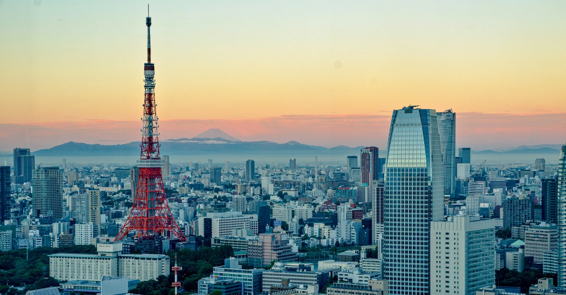 La Torre de Tokio se eleva hacia el cielo de Tokio durante el atardecer, con el monte Fuji al fondo