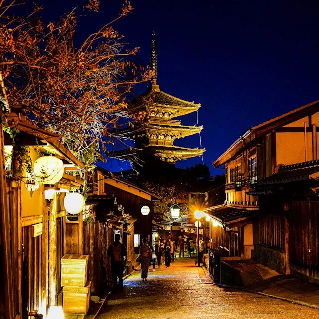 Captivating view of a traditional pagoda in Kyoto, Japan at twilight with people in kimonos walking nearby