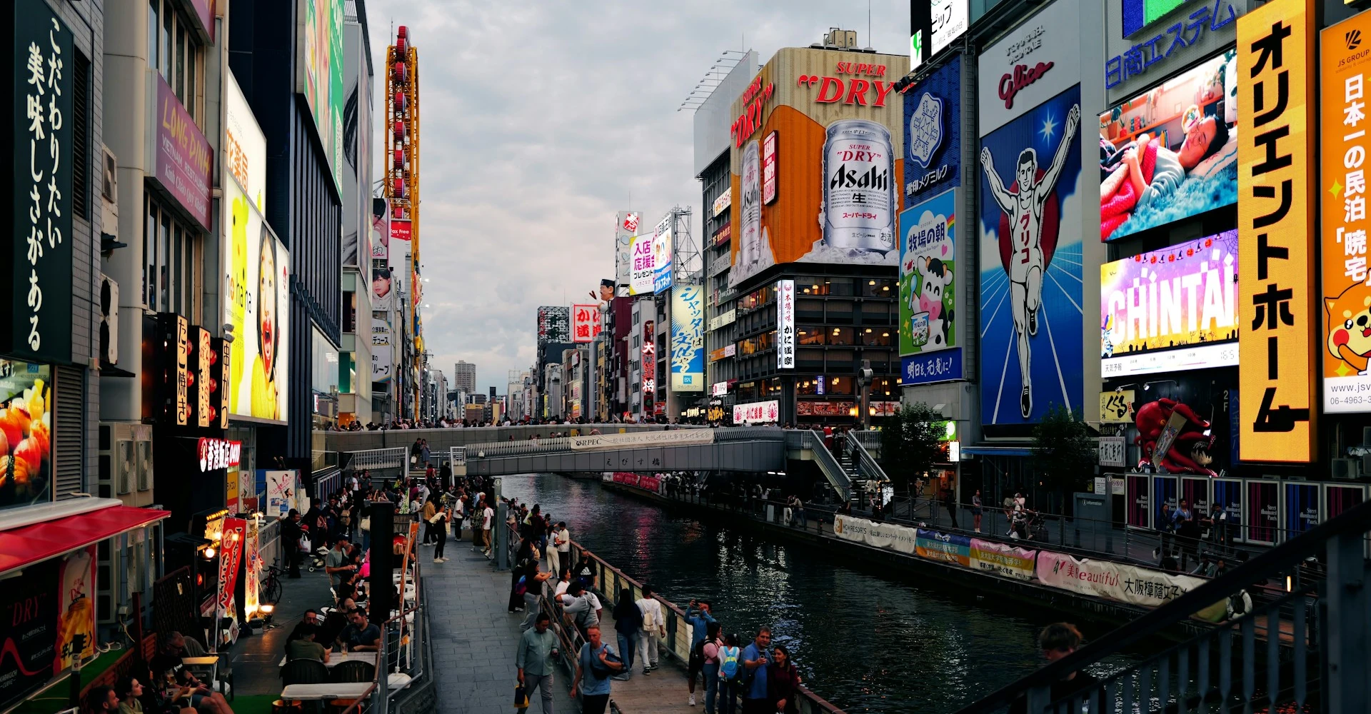 Vibrant night view of Dotonbori in Osaka with bright neon signs and lively crowds.