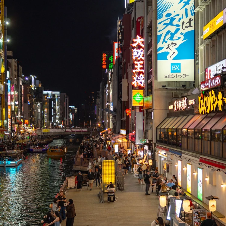 Vibrant night view of Dotonbori in Osaka with bright neon signs and lively crowds.