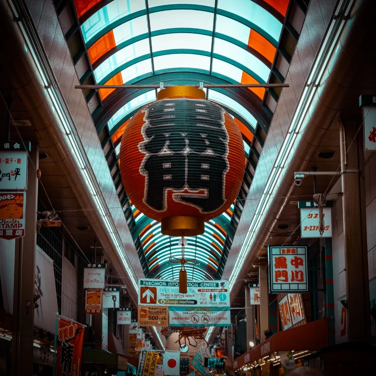 Dynamic view of Kuromon Ichiba, a bustling market street in Osaka, Japan.
