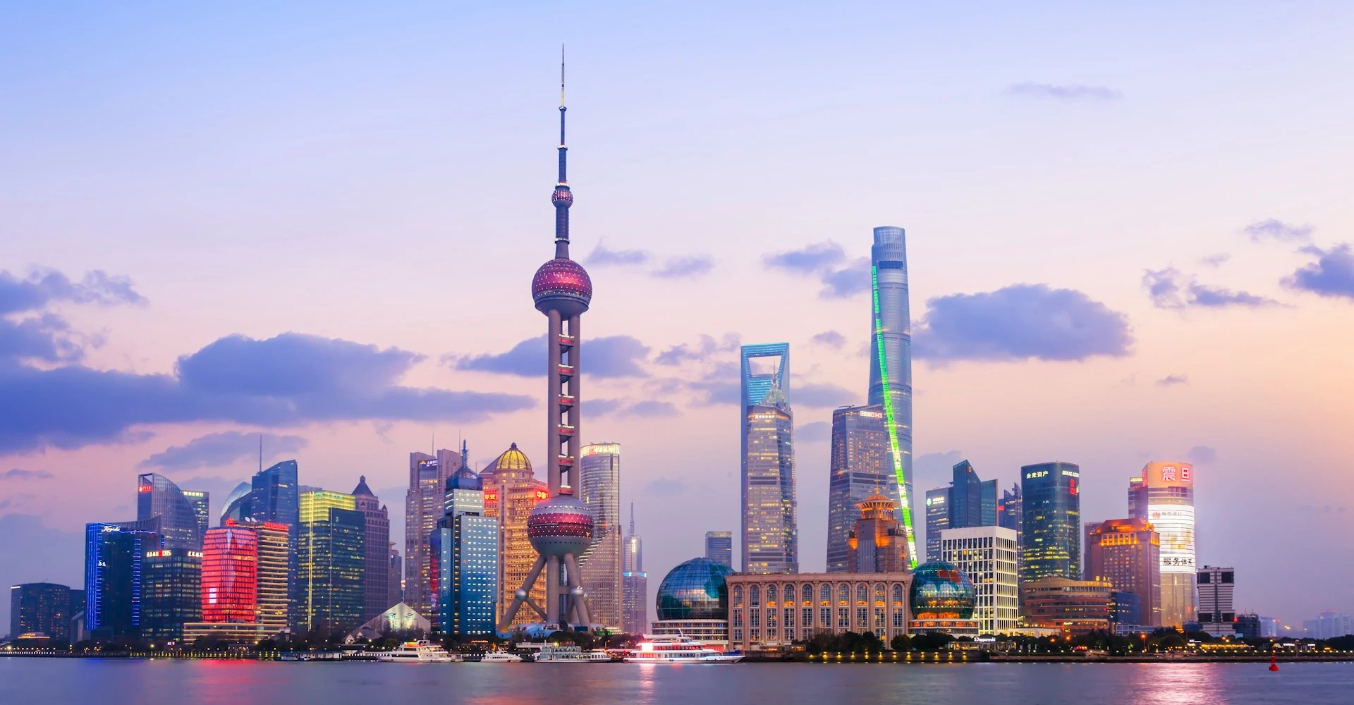 The skyscrapers of Pudong visible from the Bund promenade, with the river beneath them reflecting the lights