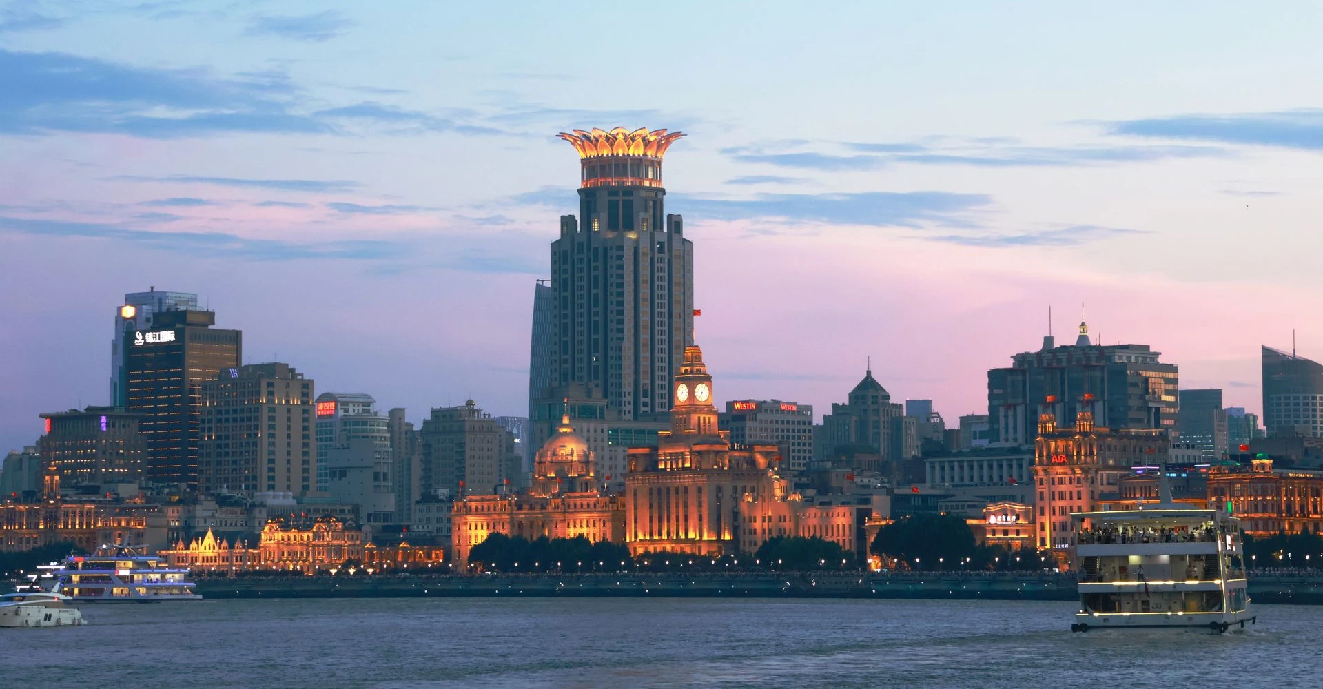 The Bund colonial buildings visible from Pudong across the river, with a passanger ferry crossing to the other side
