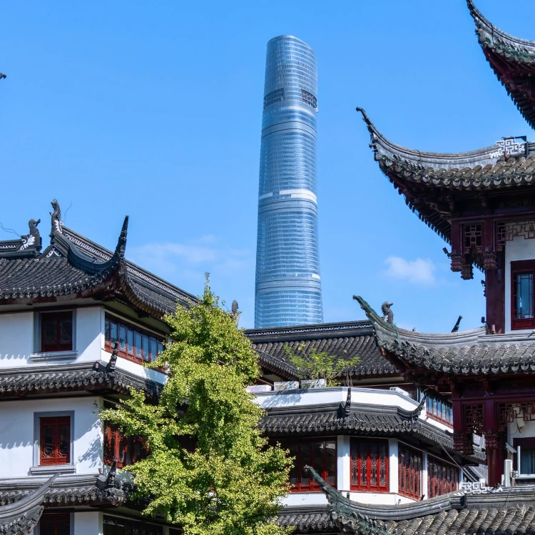 Very tall and modern skyscraper visible on the background of an asian temple complex