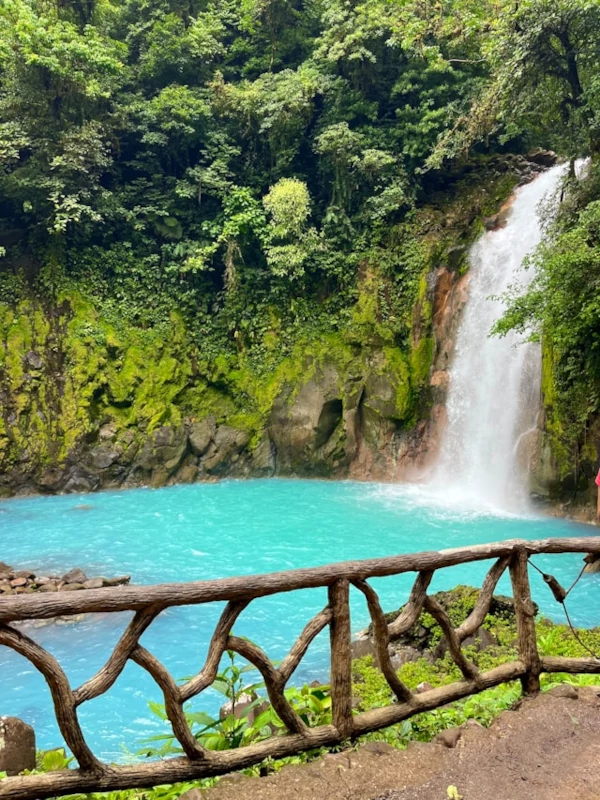 Activities in Tenorio Volcano National Park A waterfall falling on a turquoise blue river surrounded by green vegetation